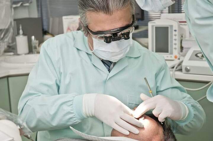 Dental professional performing a procedure related to dental bridge treatment